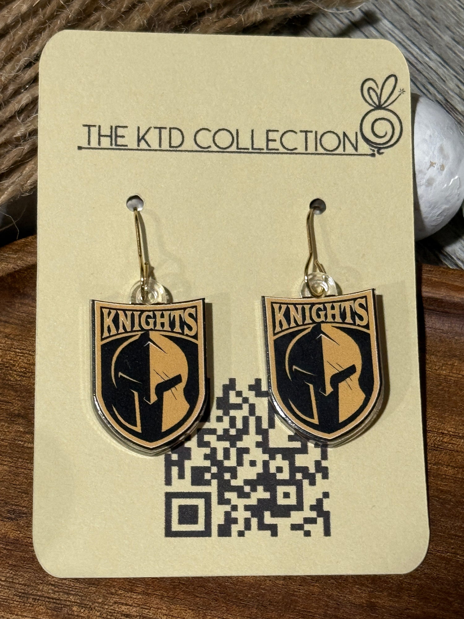 UV printed dangle earrings featuring the Canandaigua Knights logo on clear acrylic, hanging on gold hooks and displayed on The KTD Collection earring card