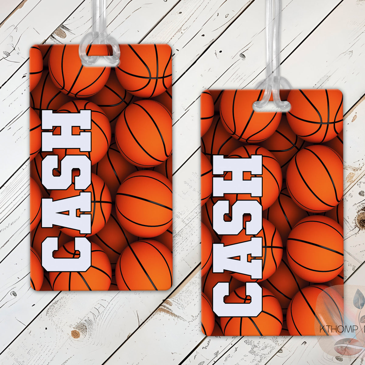 Two sports bag tags with basketball design with name and number on a wooden surface.