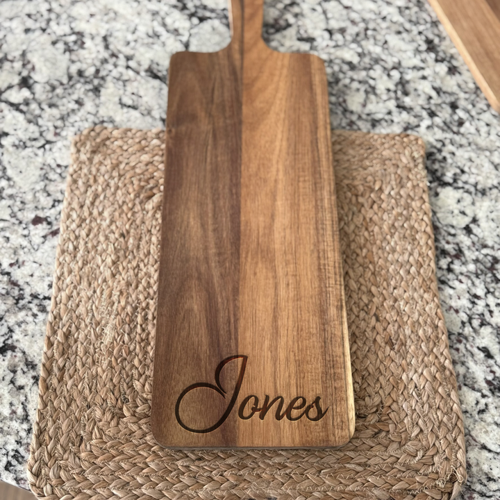 Acacia wood cutting board engraved with family name, styled for kitchen display