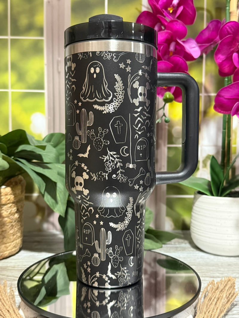 40oz black stainless steel tumbler with handle, laser engraved with Halloween ghost doodles, skulls, gravestones, and stars – ready to ship.
