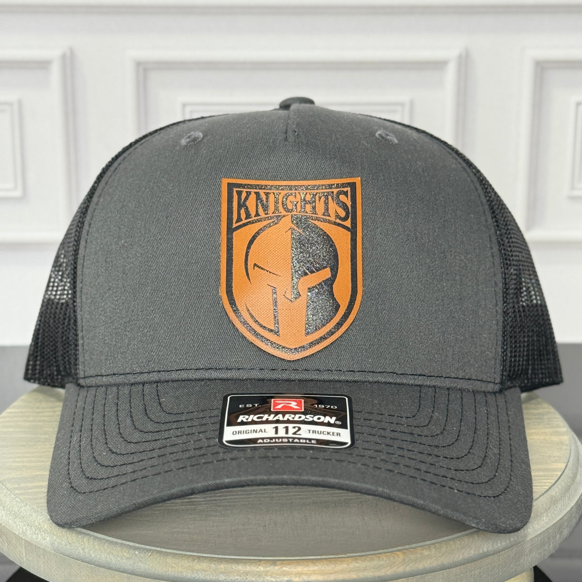Black Richardson 112 hat with custom orange leatherette patch engraved with a knights logo

