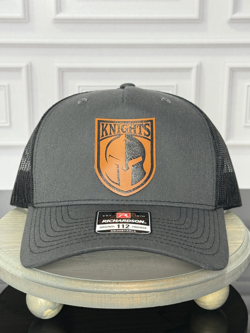 Black Richardson 112 hat with custom orange leatherette patch engraved with a knights logo

