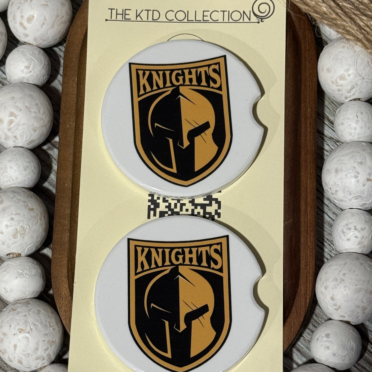 Set of two ceramic car coasters with Canandaigua Knights logo, displayed on The KTD Collection packaging with white beaded accents