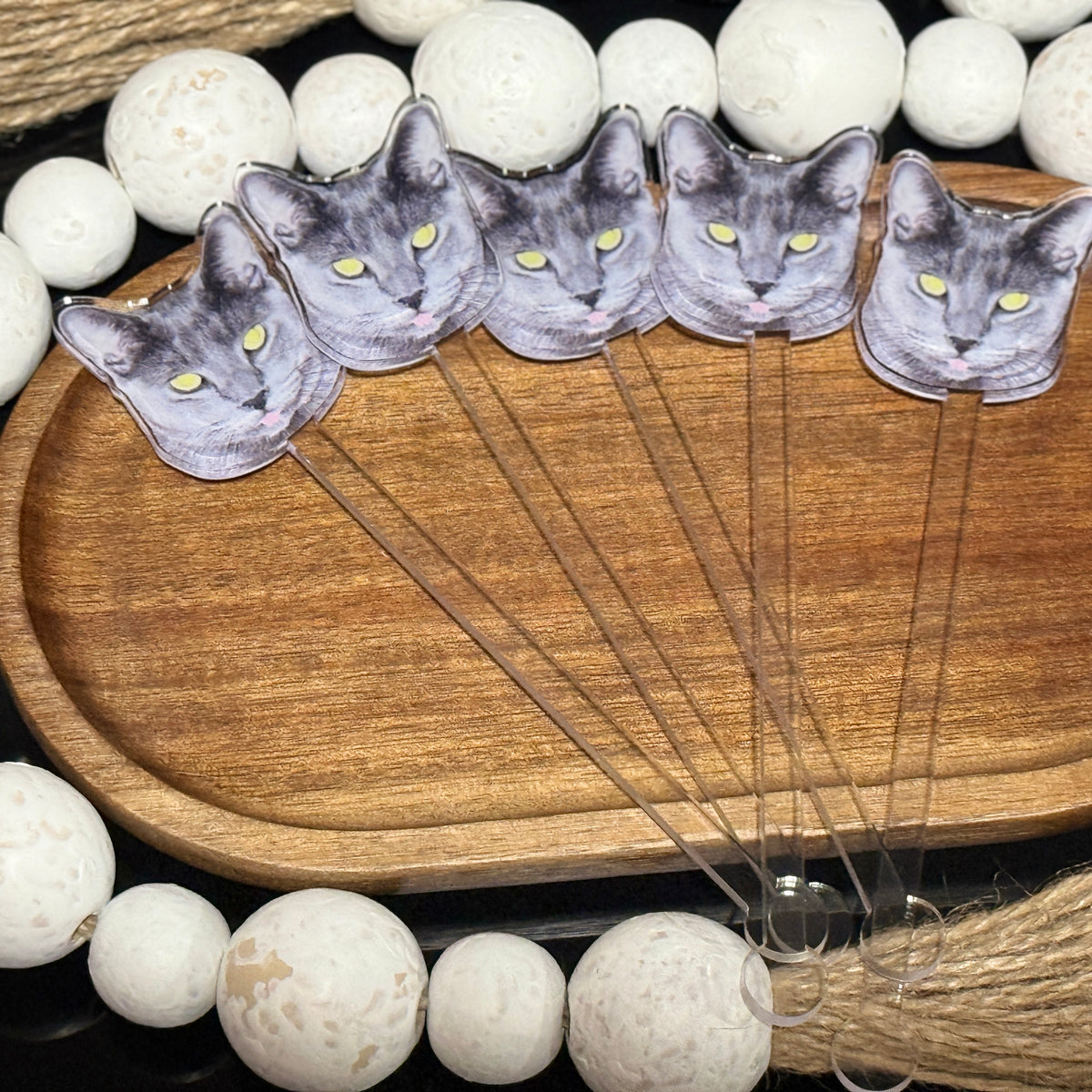 Custom acrylic drink stirrers with UV printed pet photos and logos, displayed in clear glasses with party decor in background