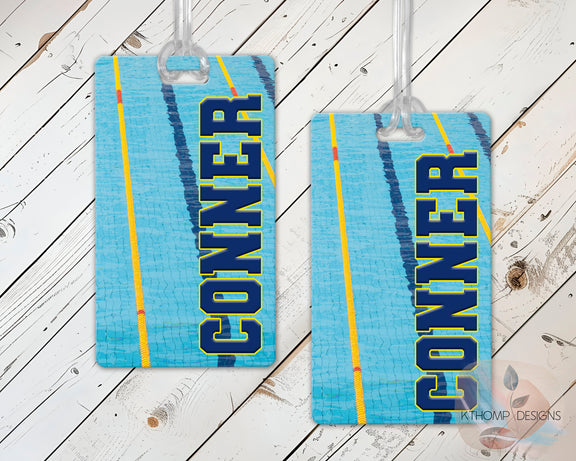 Swimming bag tags with name and swimmer graphic on a wood background